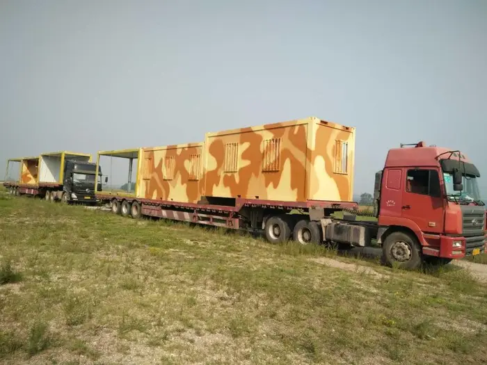 Askeri kamuflaj desenli prefabrik konteyner, TIR üzerinde nakliye edilirken; mobil askeri üs, sığınak veya komuta merkezi çözümü.