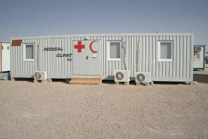 Askeri kamp ve şantiye alanları için tasarlanmış, 'Medical Clinic' yazılı ve Kızılay sembolü taşıyan prefabrik konteyner sağlık merkezi.